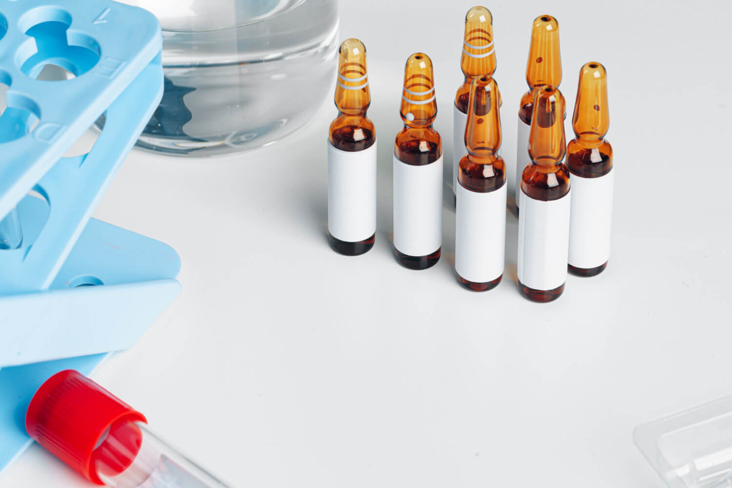 bodegón clínico ordenado con viales de laboratorio etiquetados para vitamina B12 y Vitamina D junto a un informe de resultados.