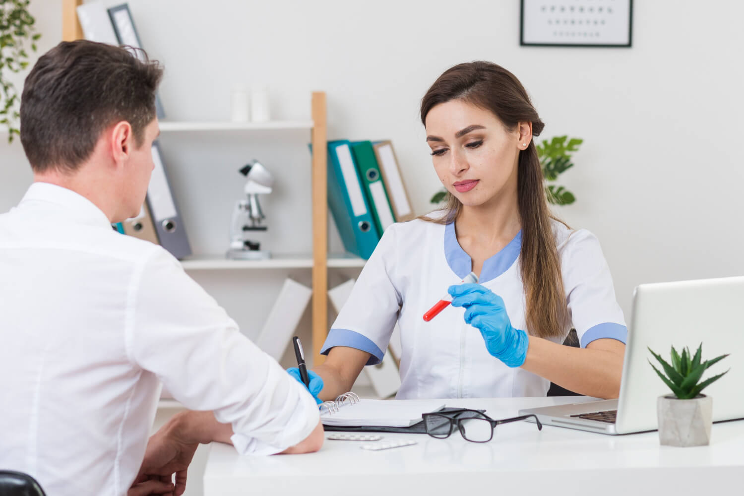 Médico explicando resultados de perfil lipídico a paciente joven en Valencia - Doctor explaining lipid profile results to a young patient in Valencia